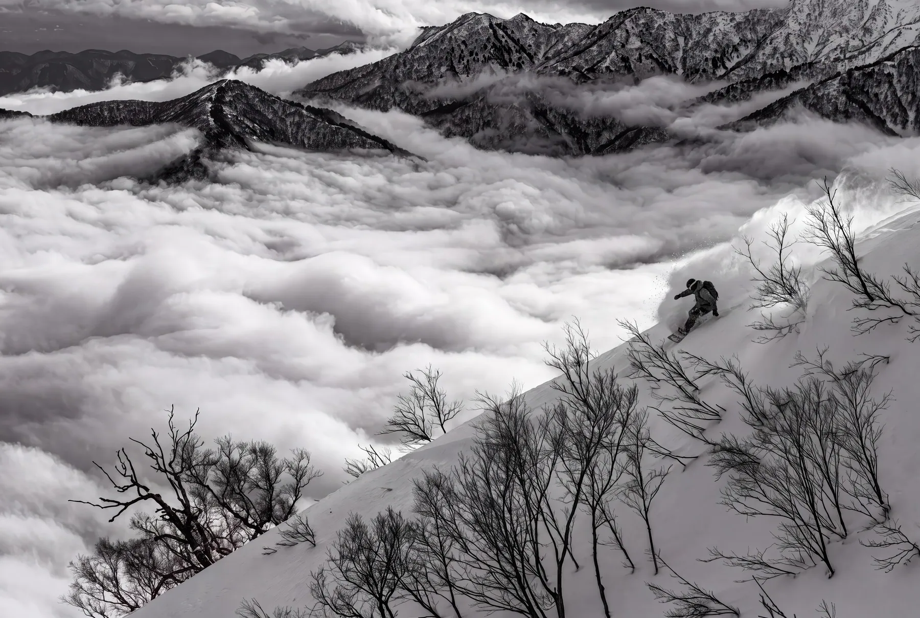 A skier traversing a ridge above a sea of cloud